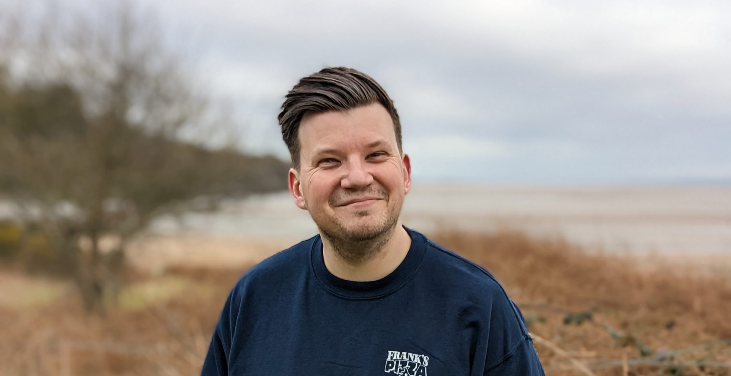 Thom Beal smiling on the coast